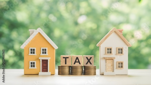 Two Houses with Tax Blocks and Coins for Real Estate Tax Concept