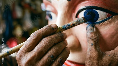 Artisan Holding Handcrafted Ondel - Ondel Decorative Brush with Blue Paint Detail