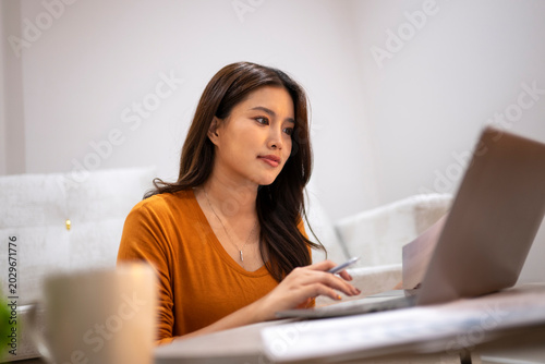 Cuadro en lienzo Asian woman working on laptop at home office
