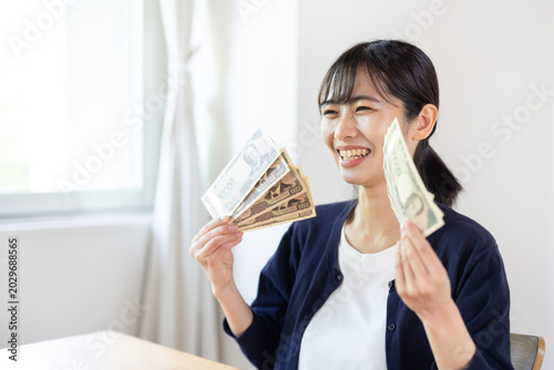 Cuadro en lienzo Asian woman smiling while holding ten 10000 yen banknotes