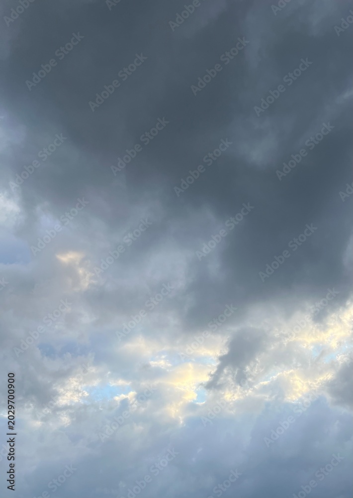 Fototapeta premium Dark dramatic storm clouds with sunlight in the sky