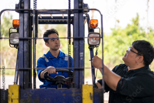 Forklift operator receiving training from experienced supervisor