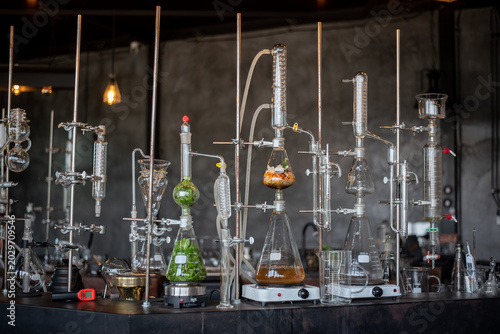 Fotografia A variety of glass distillation apparatuses and flasks filled with botanical ingredients set up on hot plates in a laboratory