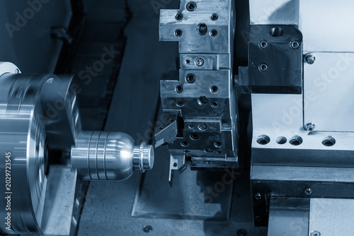 High-precision CNC lathe machine forming the core mold component of a plastic bottle shape in a light blue industrial scene.
