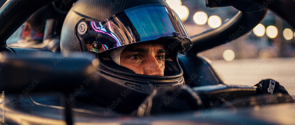 Naklejka premium Close-up of racing driver looking through helmet visor inside open-wheel car. Concept of Formula 1 concentration, motorsport media, athlete branding and race event promo. Banner