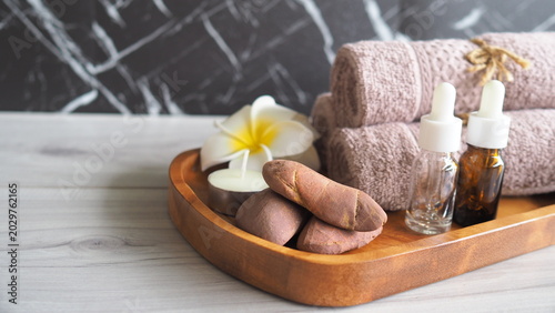 Canvas Print Spa wellness composition with rolled towels, essential oil dropper bottles, massage stones and candle on wooden tray