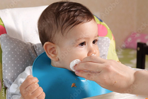 Vászonkép Mom wipes the son drool with a napkin