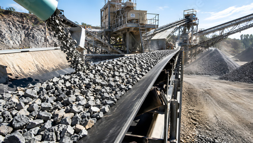 Crushed stone moving on conveyor belt at quarry plant