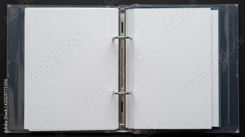 Open ring binder with blank pages isolated on black background