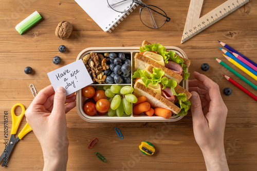 Healthy school lunch box with sandwich, fruit, vegetable and a handwritten note