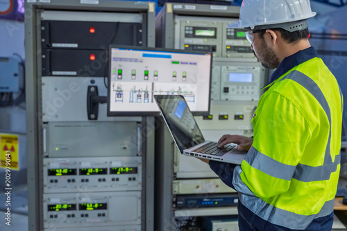 Professional engineer monitoring industrial automation system on digital screen in high-tech factory control room. Concept of smart manufacturing, technical data analysis, and modern engineering.