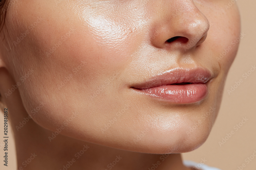 Fototapeta premium Glossy healthy skin texture close up face with natural lip shine and smooth cheek skin