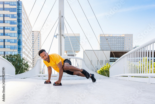 Photos Hispanic sportive man training outdoors in the city
