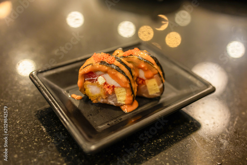 Delicious variety of sushi displayed beautifully on a clear plate during a vibrant culinary gathering