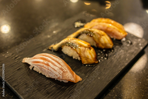 Delicious variety of sushi displayed beautifully on a clear plate during a vibrant culinary gathering
