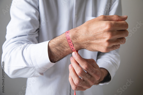 Foto Man measuring his hand with a measure tape.