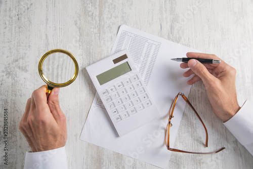 Businessman using calculator and working in financial document.