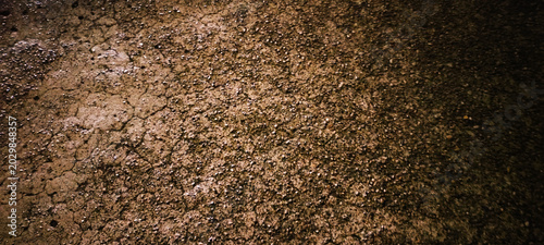 Texture of dark cracked earth and dry soil background
