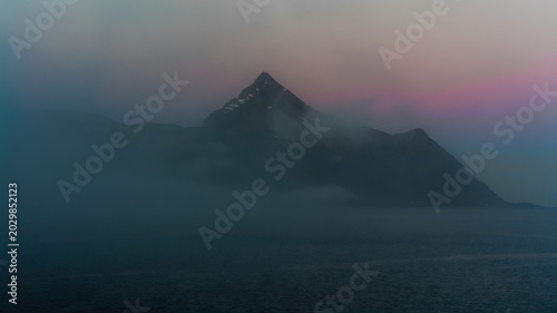 The Midnight Sun and Arctic Fog. The Midnight Sea Fog Claims the Mountainous Coast. Lofoten Islands, Northern norway.