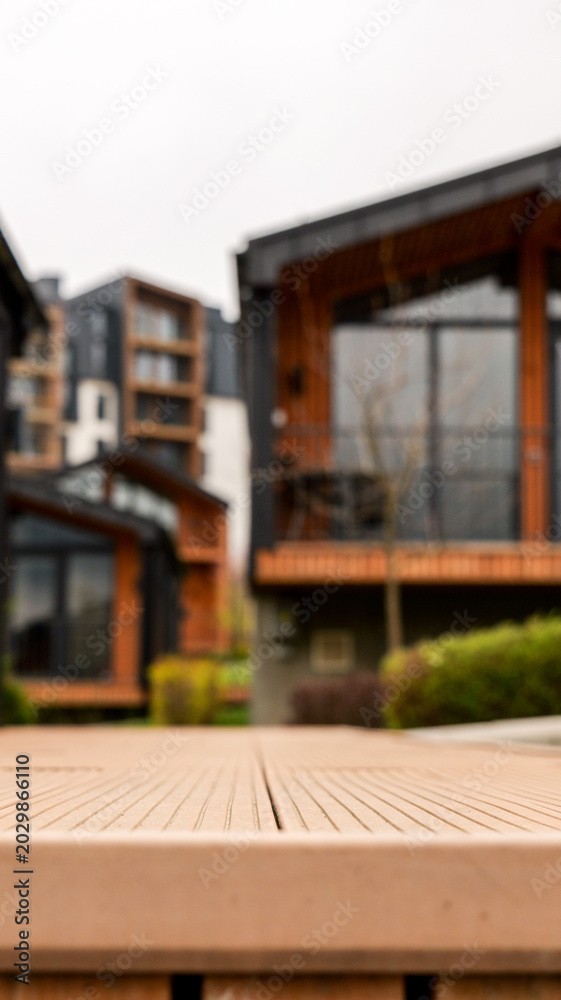 Fototapeta premium Modern wooden deck in foreground with contemporary buildings in background