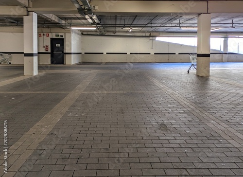 Cuadro en lienzo Garaje subterráneo vacío de supermercado con columnas de hormigón, luces y condu