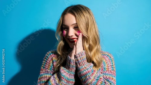 Expressive young caucasian woman showing a sequence of emotions in a fun collage. Playful female model with heart makeup laughing, winking, and feeling shy