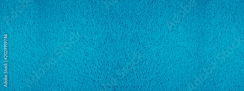 Fotografie Background of natural light blue stucco in plaster cement texture lined pattern or stone in colors aged Textured illuminated wall fence surface blend of warm sunny tones backdrop