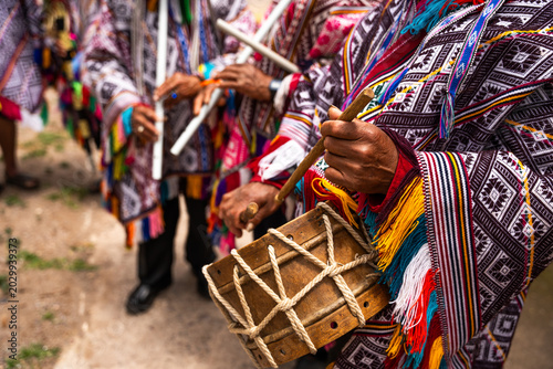 Canvastavla Hands of Andean villagers in traditional costumes playing instruments from the v