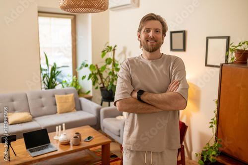 Canvas Print Fair-haired bearded man standing in the middle of the room and looking confident