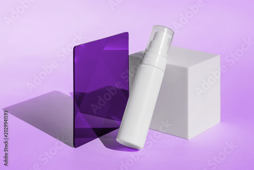 Cosmetic bottle and geometric shapes on purple background, modern minimal container design, skincare product branding template ideal for beauty promotion