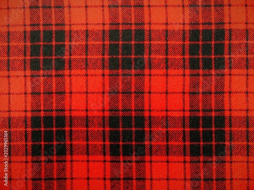 Obraz na plátně Red and black plaid texture background, traditional Scottish tartan pattern, checkered wool fabric flannel cloth close up