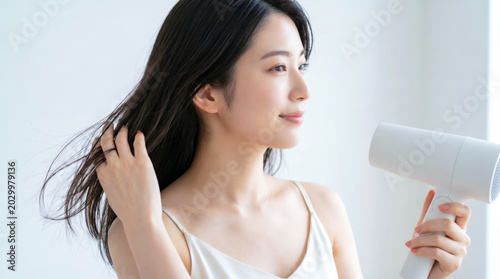 ドライヤーで髪を乾かす若い女性 ヘアケア