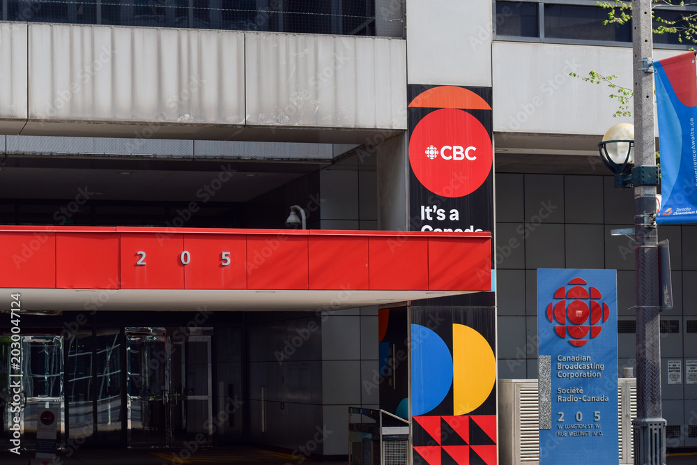 Naklejka premium Entrance to the CBC building on Wellington Street in downtown Toronto, showing corporate signage and urban architecture of the Canadian broadcasting headquarters in May 2026