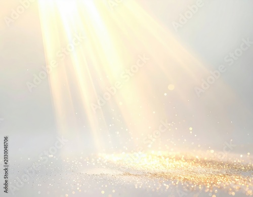 Golden beams of light illuminate shimmering particles on a bright surface