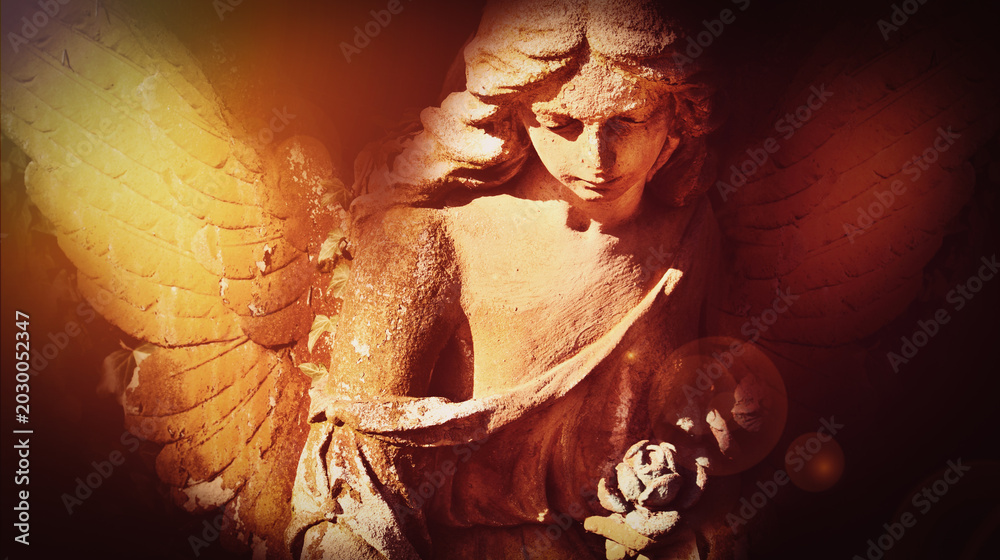 Fototapeta premium Gothic cemetery angel with illuminated wings and emotional atmosphere