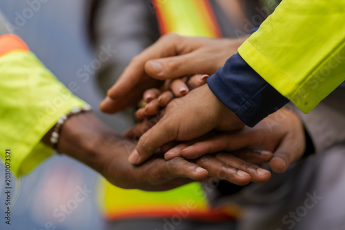 Konstfotografi Team logistics workers in high visibility safety gear and hard hats discuss operations at a busy shipping container yard