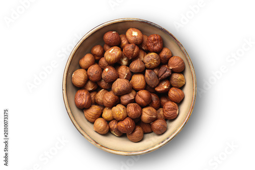 Foto Hazelnuts in ceramic bowl isolated on light background