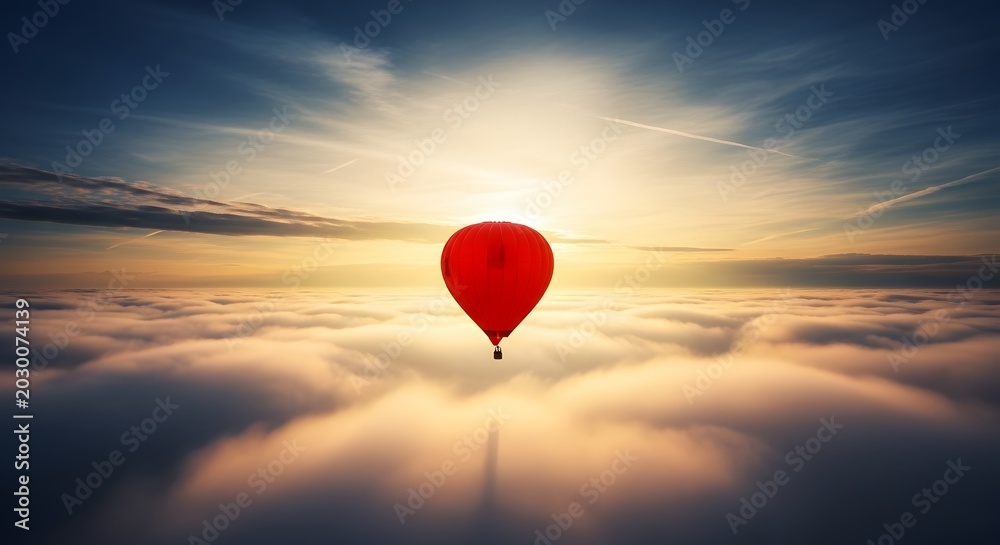 Fototapeta premium A single red heart shaped balloon floating above a sea of clouds at sunset.