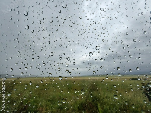 Rain Drops on Car Window – Travel Perspective and Vacation Landscape..