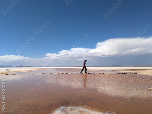 Obraz na plátně Man balancing on stone path across water pool at Salar de Uyuni salt flat in Bol