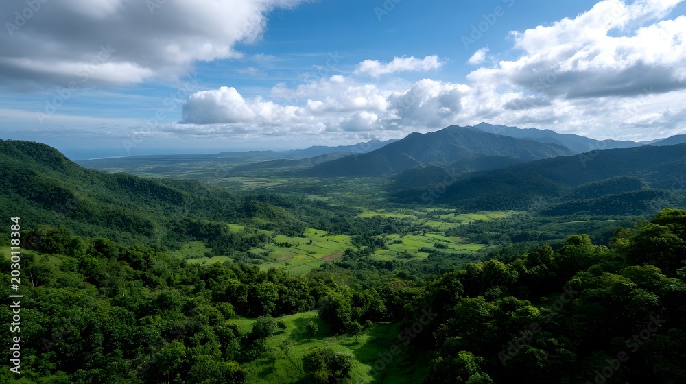 Fototapeta premium An expansive view of rolling green valleys and fields under a dramatic cloudy sky