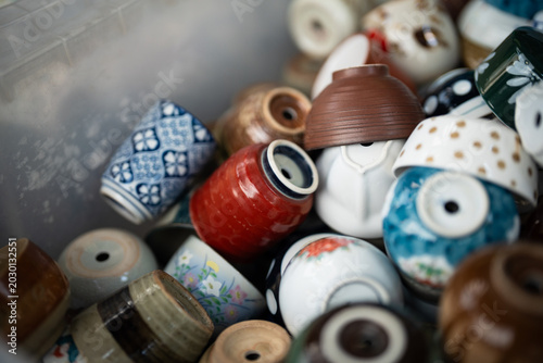 Tableau sur toile Recycle and reuse old tableware, pile of ceramic mugs reproduced as pots for pla