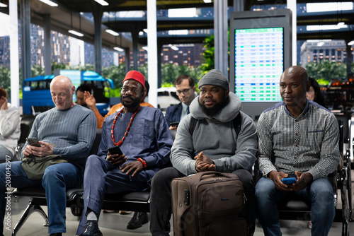 Fotografia Modern bus terminal with people sitting in waiting area before departure