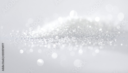 Fine, sparkling white particles scattered on a bright, blurred background
