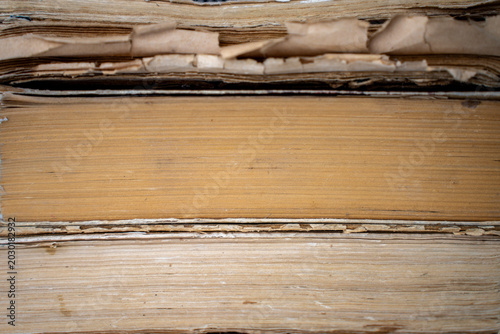 Εκτύπωση καμβά Macro texture of aged yellowed paper pages and worn edges of stacked old antique books, representing an abstract library background, historical archives, and literature