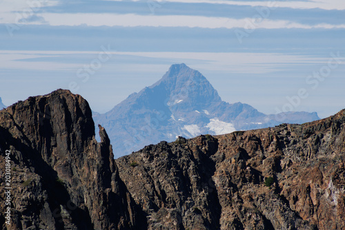 A rocky mountain peak set against a mountain range.