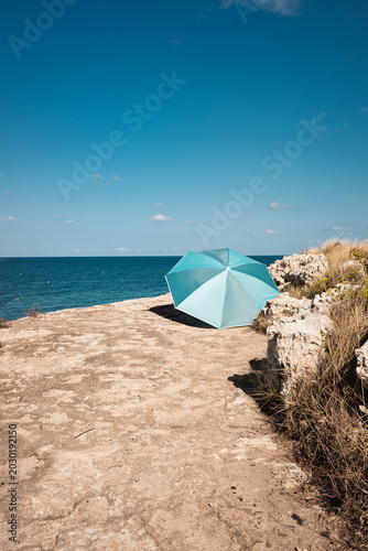 Umbrella on beach rocks and Apulia seascape in Monopoli, travel destination view