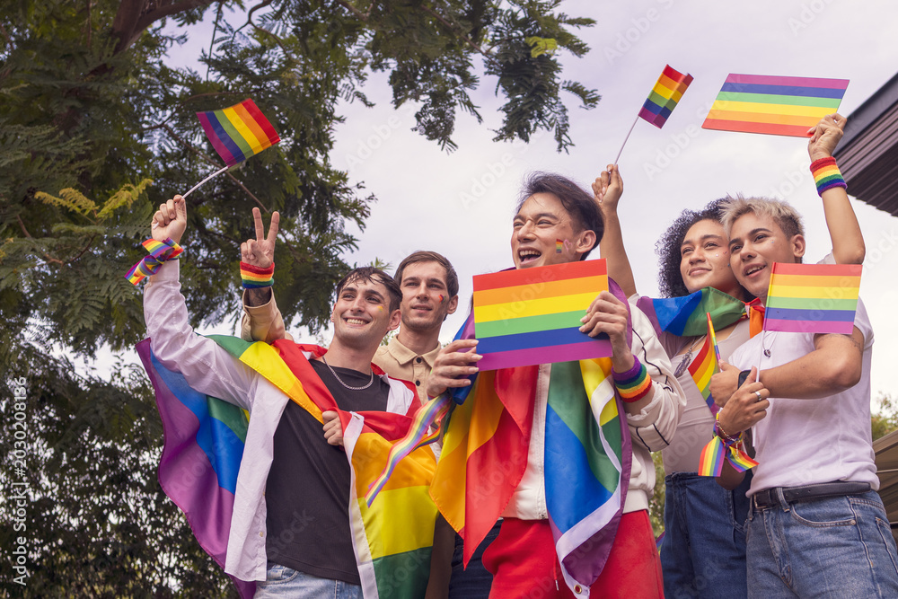 Fototapeta premium Pride month. Friends from IGBTQ, men, women, lesbians, and transgender people of various nationalities joined the parade, carrying signs and flags celebrating equal rights at Pride Festival.
