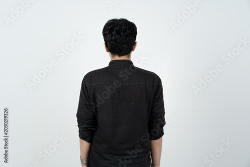 Back view of a young Asian man standing isolated on white background