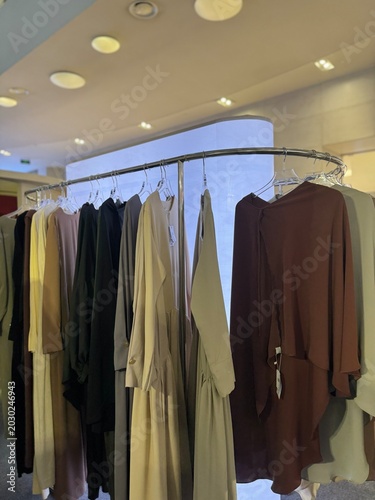 Modest Muslim Women Dresses Hanging on Curved Clothing Rack in Fashion Boutique
